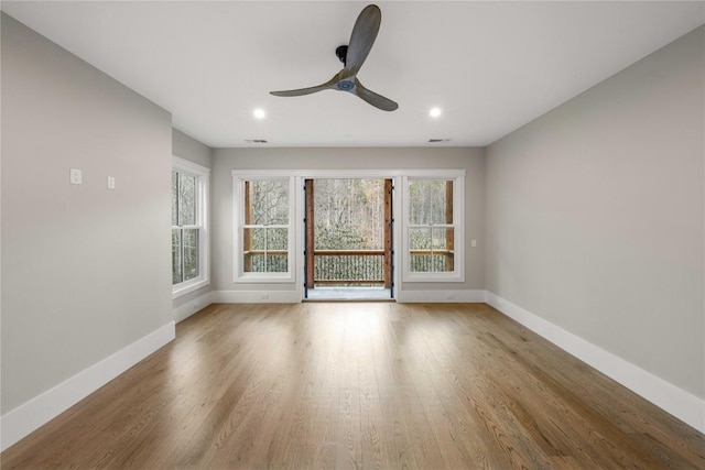 spare room with ceiling fan, wood finished floors, and baseboards