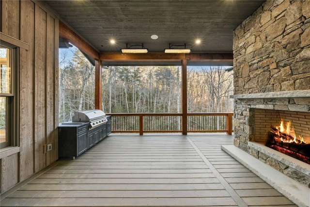 unfurnished sunroom with wood ceiling and an outdoor stone fireplace