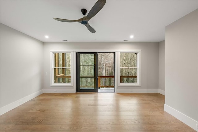 spare room featuring baseboards, wood finished floors, and recessed lighting