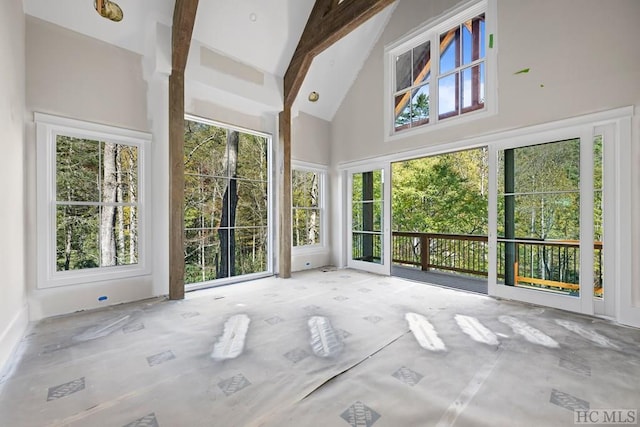 unfurnished sunroom featuring vaulted ceiling with beams