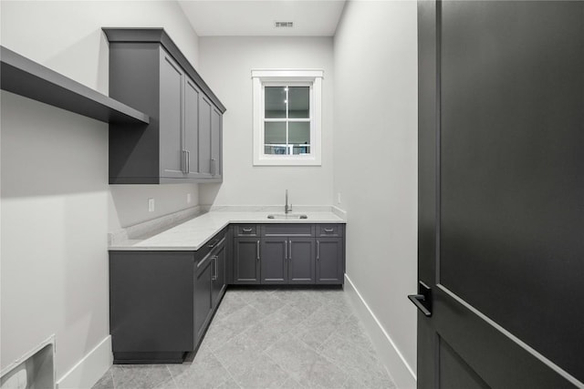 interior space with a sink, visible vents, and baseboards