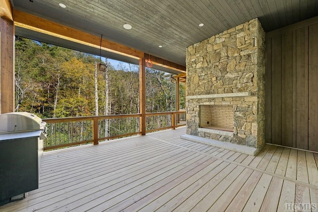 wooden deck with an outdoor stone fireplace