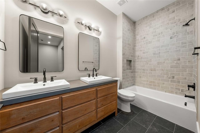 bathroom featuring toilet, a sink, visible vents, and tile patterned floors