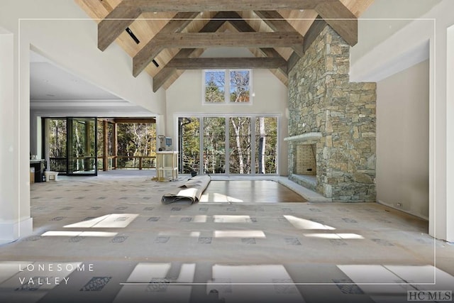 unfurnished living room featuring high vaulted ceiling, a wealth of natural light, and beamed ceiling