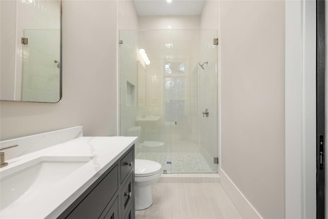 full bathroom featuring toilet, a stall shower, and vanity