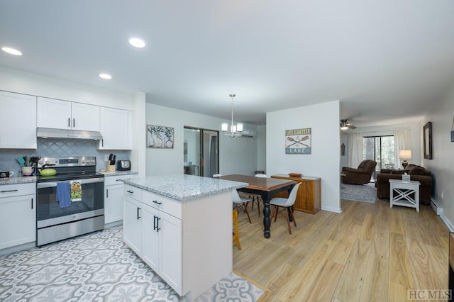 kitchen featuring pendant lighting, white cabinets, backsplash, light stone counters, and stainless steel electric range