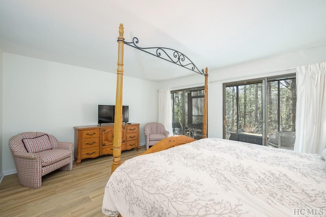 bedroom featuring access to exterior, multiple windows, and light hardwood / wood-style flooring