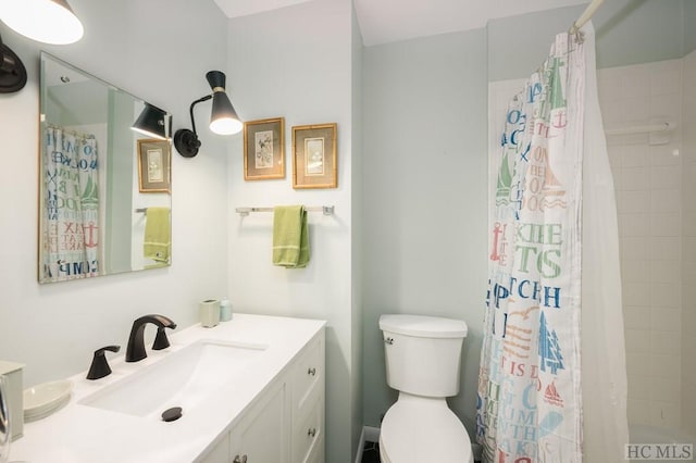 bathroom featuring toilet, vanity, and walk in shower