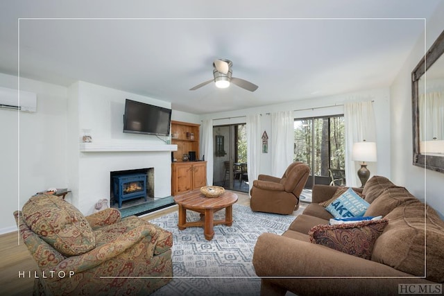 living room with ceiling fan, an AC wall unit, and light hardwood / wood-style floors