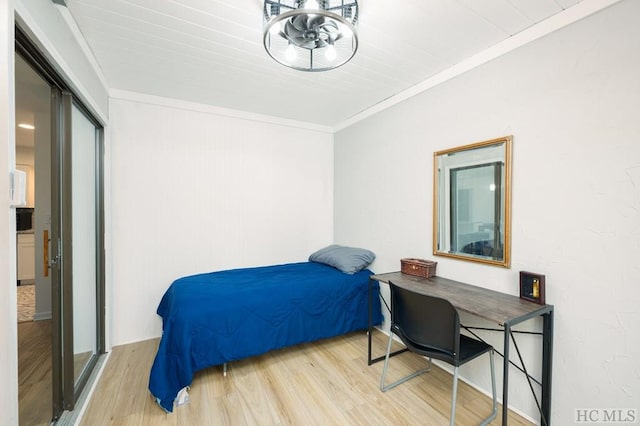 bedroom featuring crown molding and light wood-type flooring