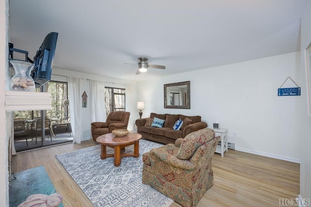 living room featuring ceiling fan, light wood-type flooring, and a baseboard radiator