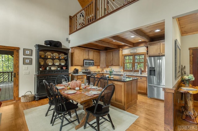 dining area with wood ceiling, beam ceiling, sink, and light wood-type flooring