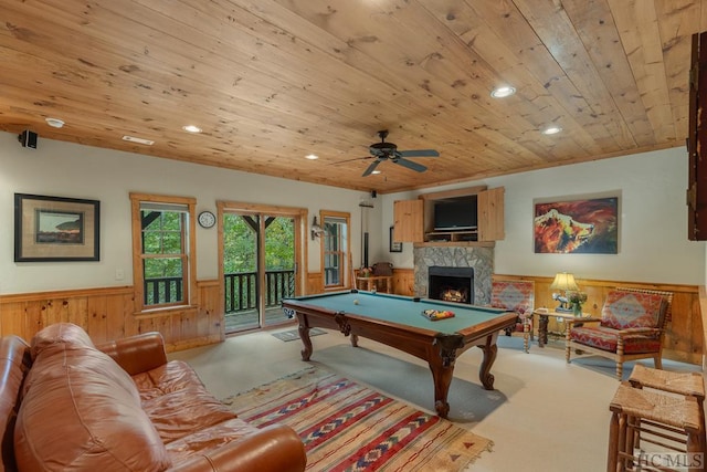 recreation room with wood ceiling, a stone fireplace, pool table, and light colored carpet