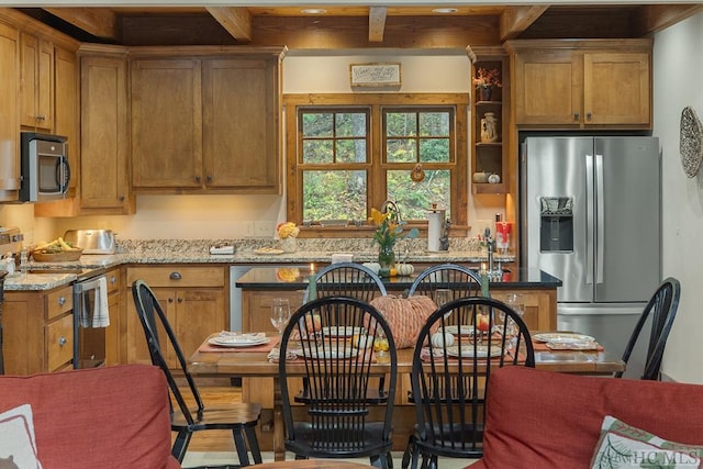 kitchen with appliances with stainless steel finishes and light stone counters