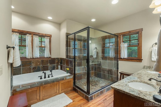 bathroom featuring vanity, hardwood / wood-style flooring, and plus walk in shower