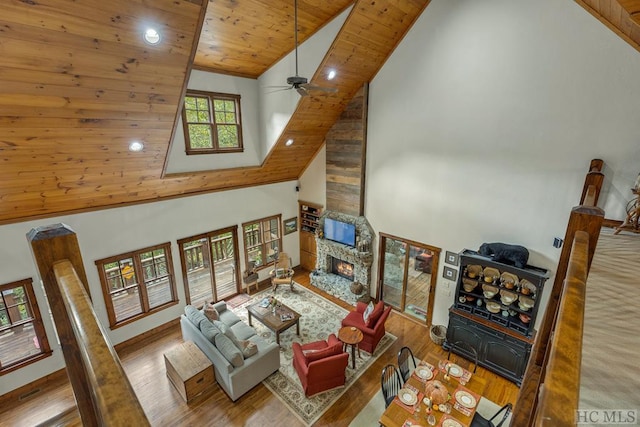 living room with a stone fireplace, high vaulted ceiling, wooden ceiling, and hardwood / wood-style flooring