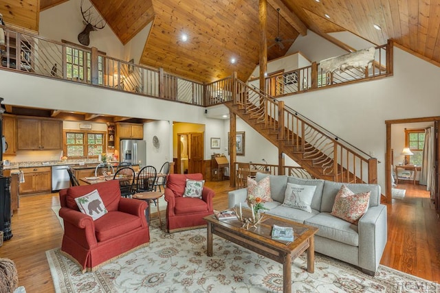 living room with wood ceiling, high vaulted ceiling, and light hardwood / wood-style floors