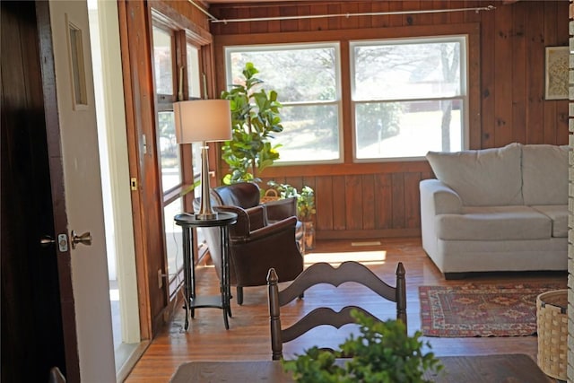 living room featuring wooden walls and light wood-style floors