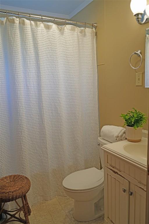 full bath with curtained shower, toilet, and vanity