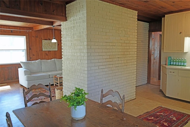 dining area with wooden walls, wooden ceiling, and brick wall