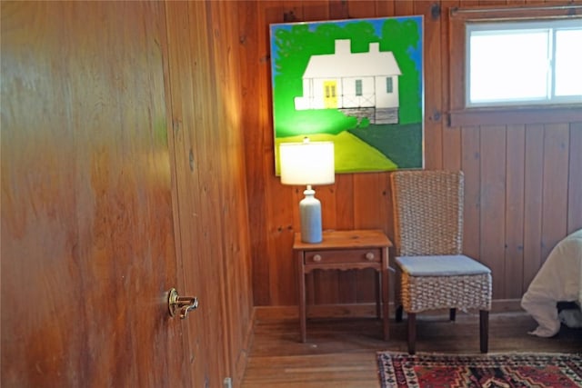 sitting room featuring wooden walls and wood finished floors