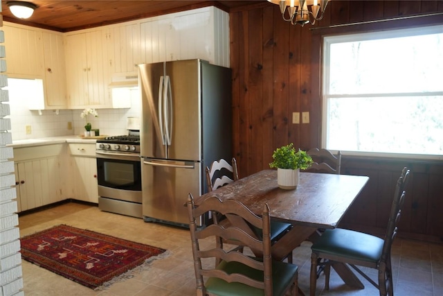 kitchen with under cabinet range hood, a healthy amount of sunlight, stainless steel appliances, and light countertops