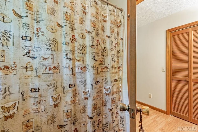 bathroom featuring hardwood / wood-style floors and a textured ceiling