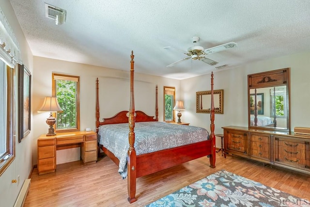 bedroom with baseboard heating, ceiling fan, a textured ceiling, and light wood-type flooring