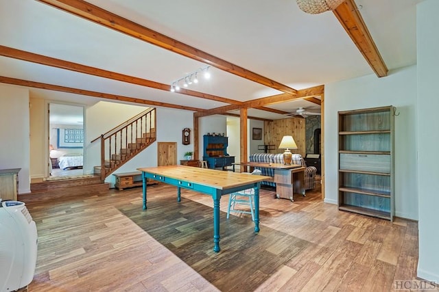 rec room featuring beamed ceiling, ceiling fan, rail lighting, and light hardwood / wood-style flooring