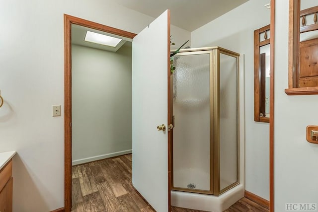 bathroom featuring vanity, hardwood / wood-style flooring, and a shower with shower door