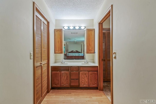 bathroom featuring vanity, wood-type flooring, and a textured ceiling