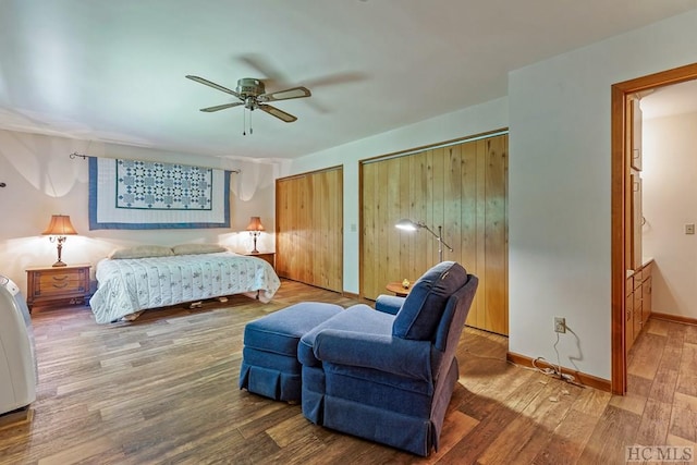 bedroom with multiple closets, wood-type flooring, and ceiling fan