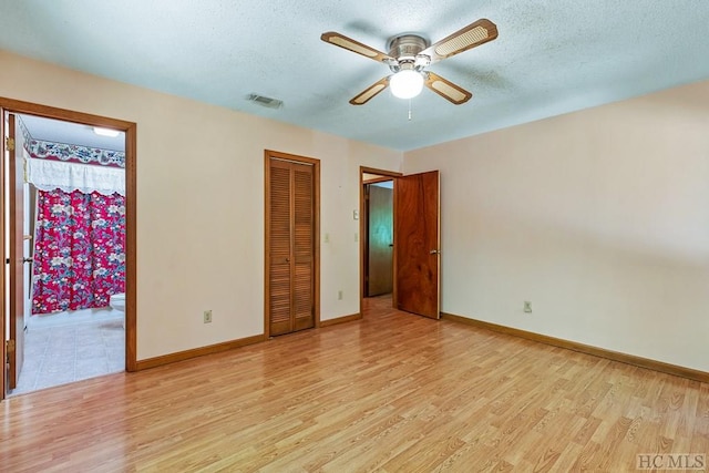 unfurnished bedroom with a textured ceiling, ceiling fan, and light wood-type flooring