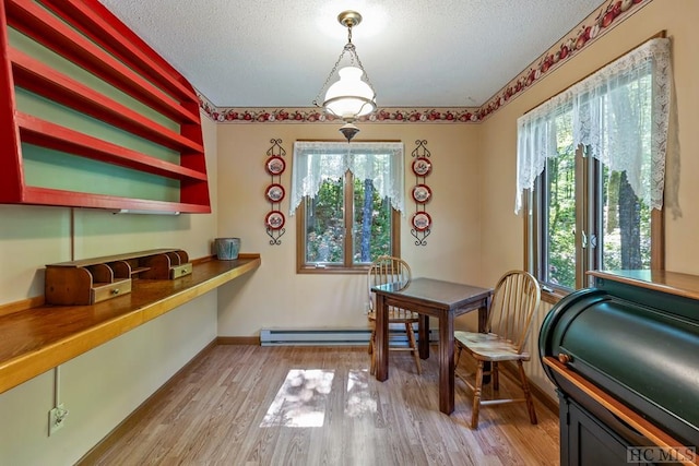 dining room featuring a baseboard radiator, built in desk, a textured ceiling, and light hardwood / wood-style floors