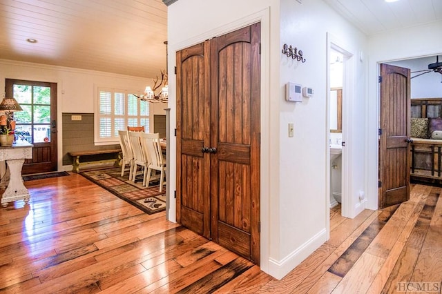 corridor featuring an inviting chandelier and light wood-type flooring