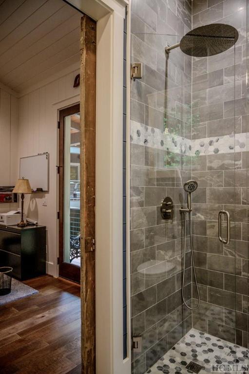 bathroom with hardwood / wood-style flooring and walk in shower