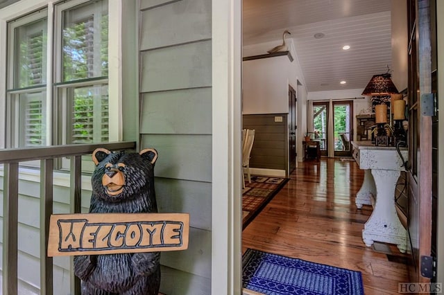 interior details with wooden walls, hardwood / wood-style floors, and wooden ceiling