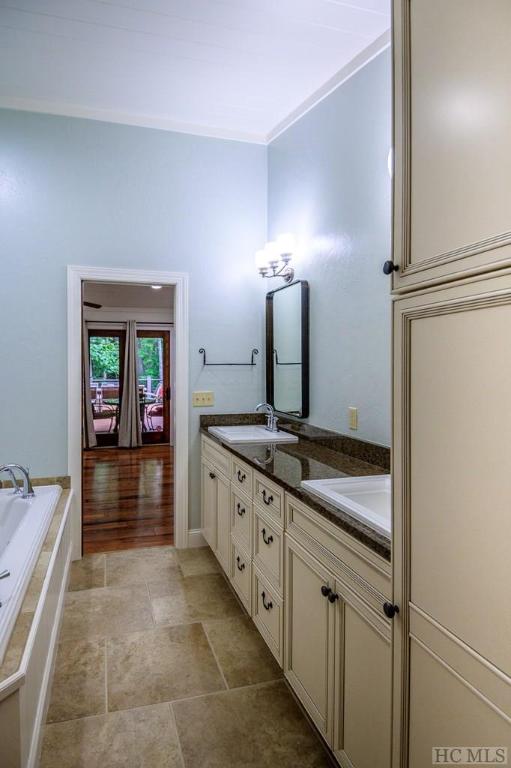 bathroom featuring vanity and tiled bath