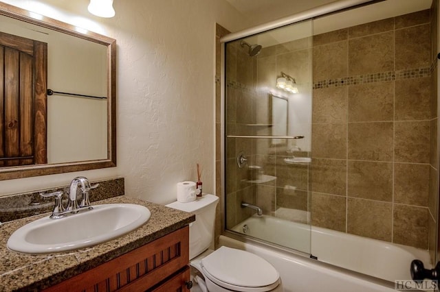 full bathroom featuring vanity, shower / bath combination with glass door, and toilet