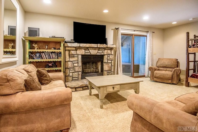 living room featuring a stone fireplace and carpet