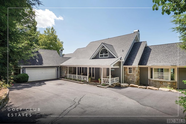 view of front of home featuring an attached garage, stone siding, driveway, roof with shingles, and a chimney