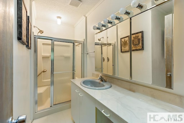 bathroom featuring vanity, crown molding, a stall shower, visible vents, and a textured ceiling