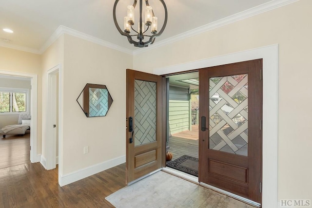 entrance foyer featuring a notable chandelier, hardwood / wood-style flooring, and ornamental molding