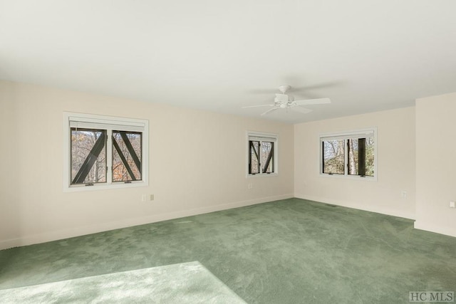 spare room featuring ceiling fan and dark carpet