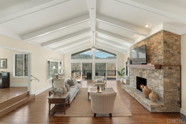 living room featuring ceiling fan, a fireplace, lofted ceiling with beams, and wood-type flooring