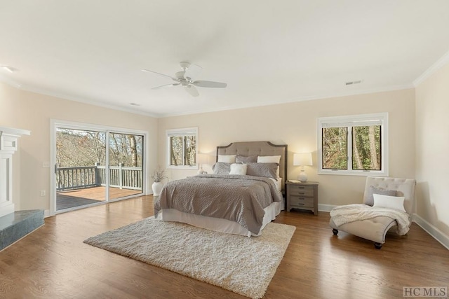 bedroom with ceiling fan, access to exterior, multiple windows, and a fireplace