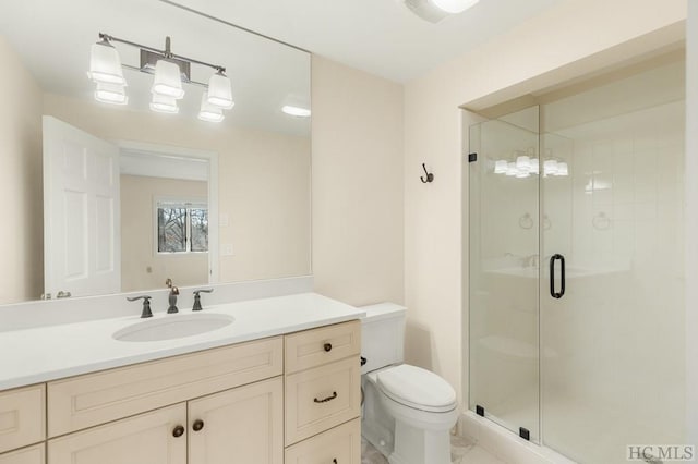 bathroom featuring vanity, a shower with shower door, and toilet