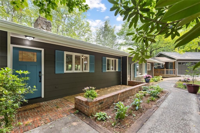 66 Hemlock Ln, Highlands, NC 28741 - view of exterior entry with covered porch and a chimney