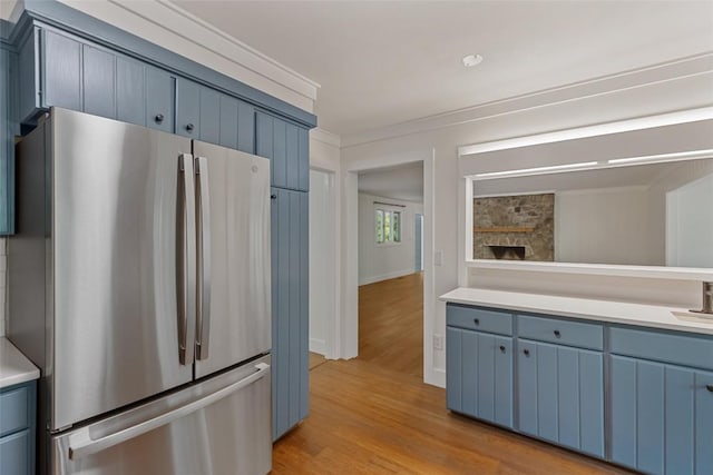 66 Hemlock Ln, Highlands, NC 28741 - kitchen featuring freestanding refrigerator, blue cabinets, light wood-type flooring, light countertops, and ornamental molding
