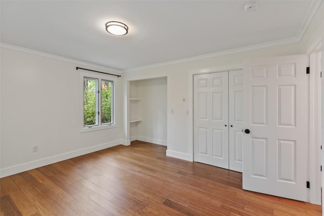 66 Hemlock Ln, Highlands, NC 28741 - unfurnished bedroom with light wood-style floors, multiple closets, crown molding, and baseboards